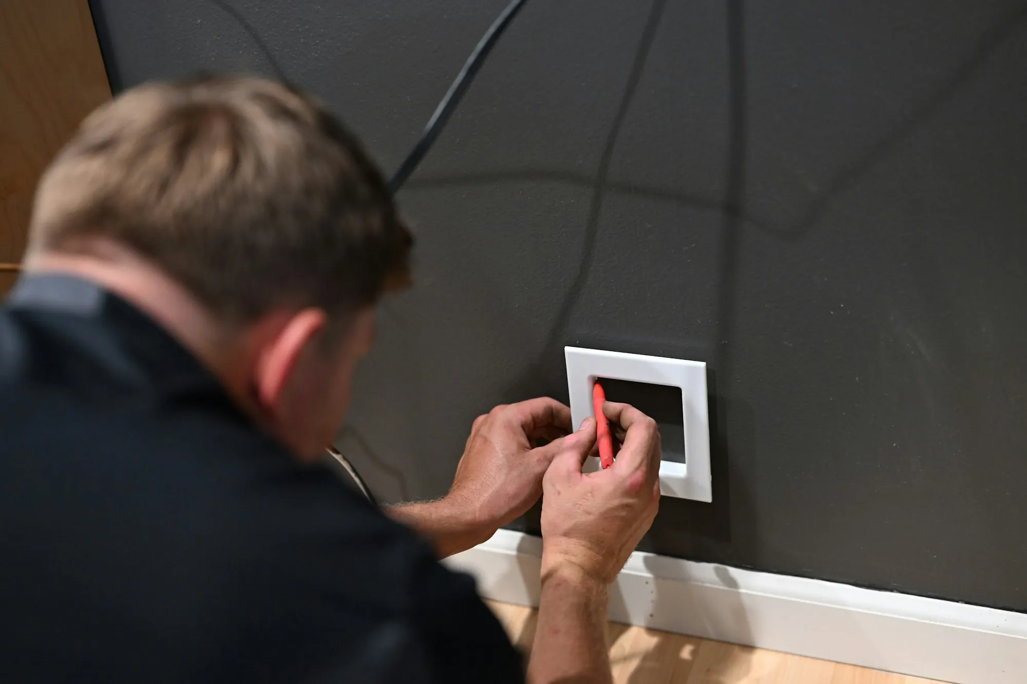 Electrician fitting a cover plate over a new wall switch